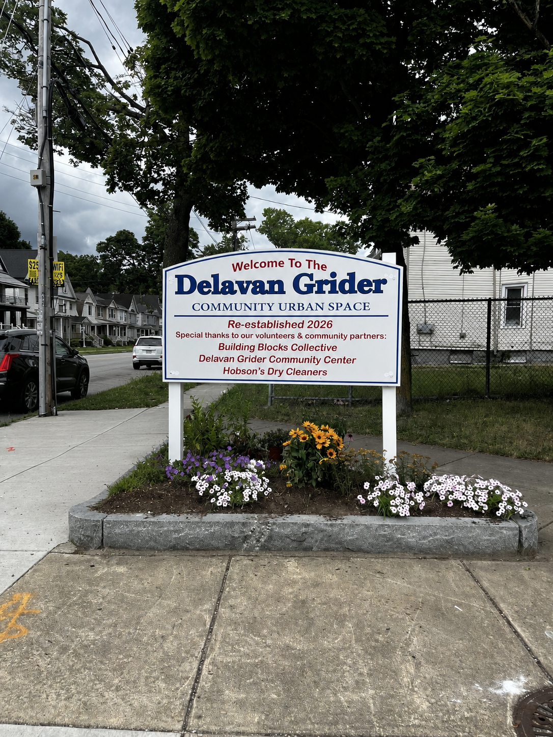 The renewed Delavan Grider Community Urban Space with its new sign and flower garden